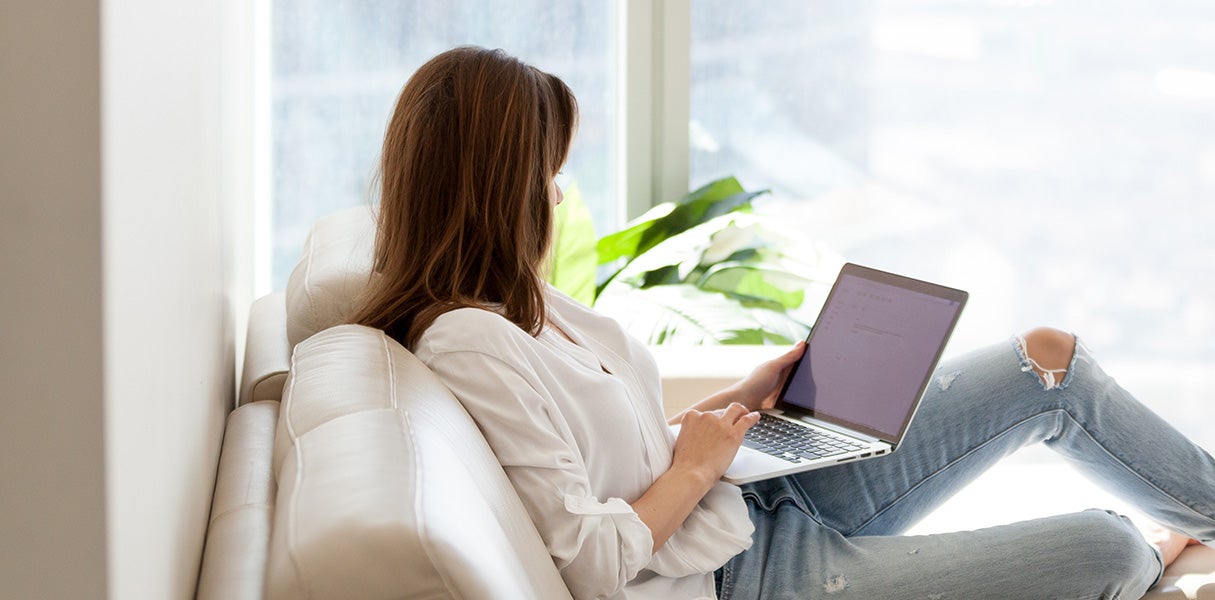 Woman using laptop on sofa